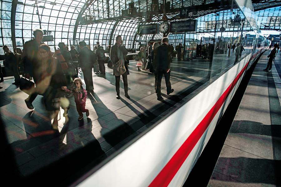 Passenger rail: Passengers on a platform reflected in the window of an ICE train